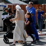 A child safely evacuates with family members after leaving the school located within the Islamic Center in San Diego, California, USA—the site of a gun attack. May 18, 2026. Photo: Reuters.